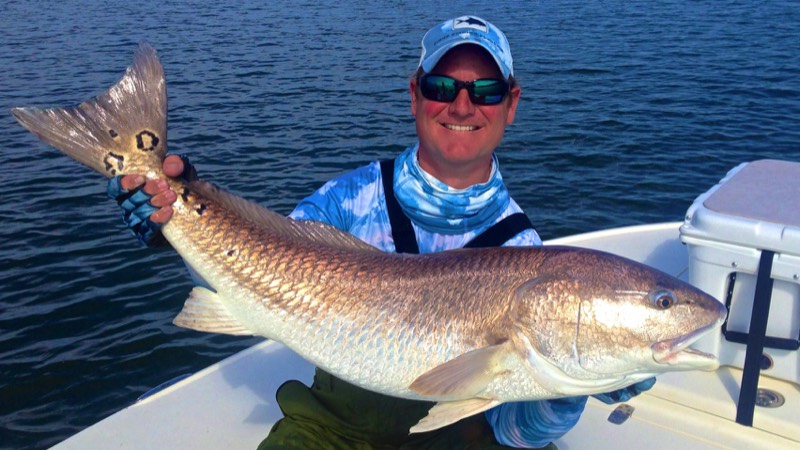 Hilton Head fishing guide Capt Blair holds huge red fish caught on charter trip