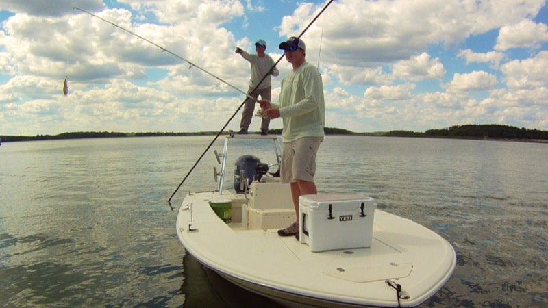 Guide and client on flats boat fishing charter