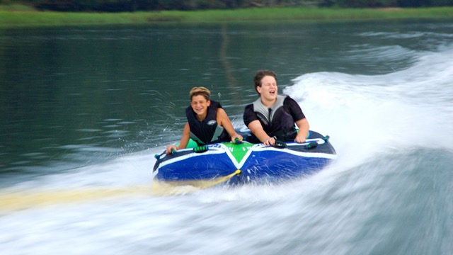 two kids tubing in hilton head on boat trip